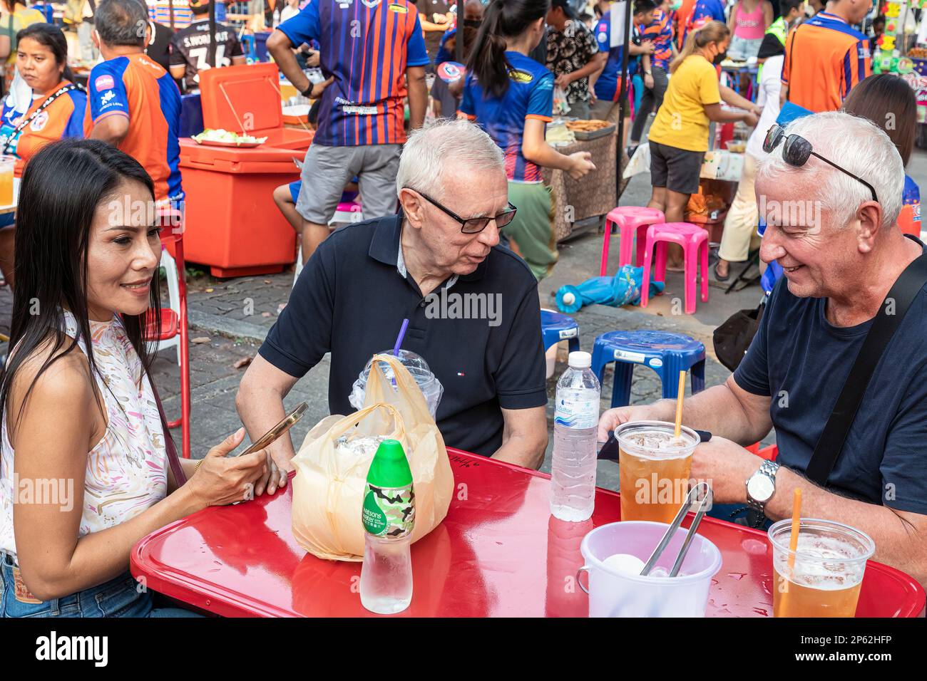 Europäische und lokale thailändische Fans essen und trinken vor dem thailändischen Fußballspiel in Bangkok, Thailand Stockfoto