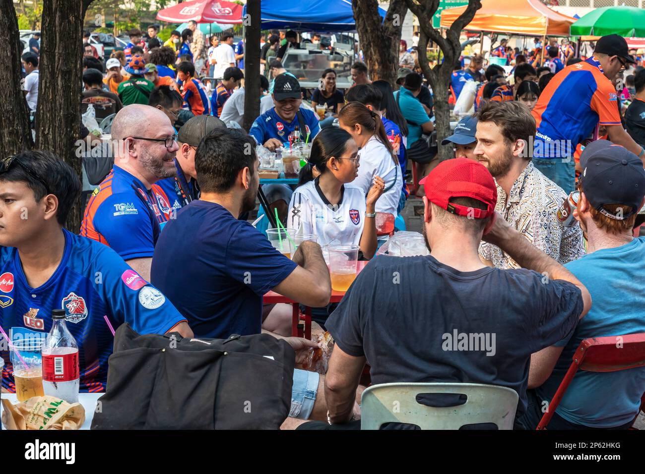 Thailändische Fußballfans essen und trinken vor dem Heimspiel, Klong Toei, Bangkok, Thailand Stockfoto