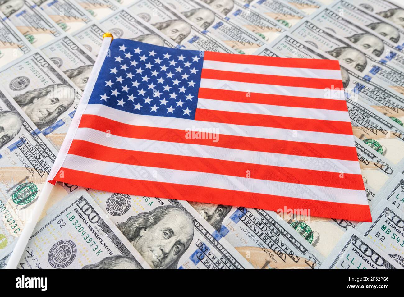 Hintergrund der US-Dollar-Banknote und der US-Flagge. Wirtschaft der US-amerikanischen Flagge und Bargeld in Dollar. Stockfoto