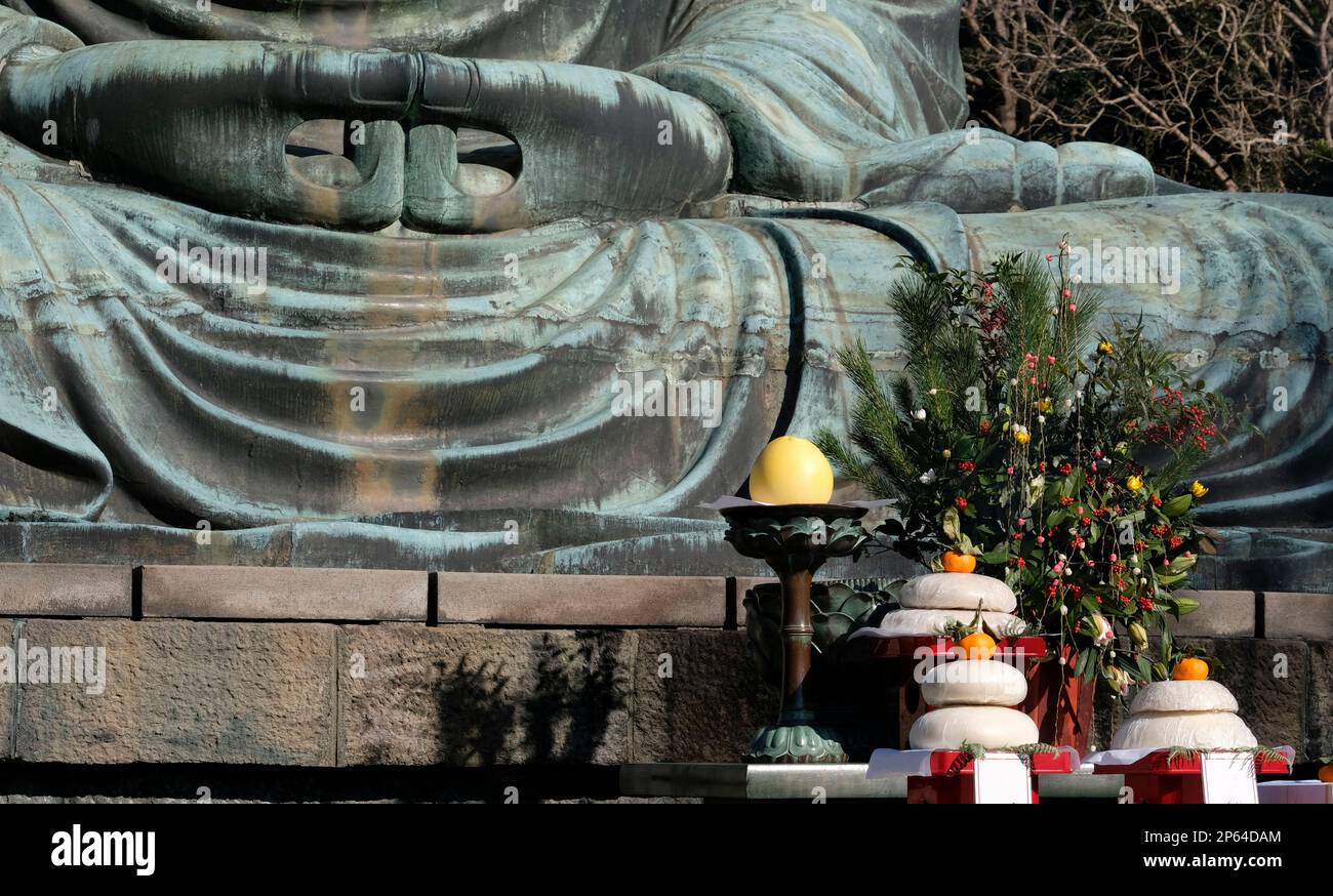 Nahaufnahme der Hände des Großen Buddha in Kamakura, Japan, mit traditioneller Neujahrsdekoration Stockfoto