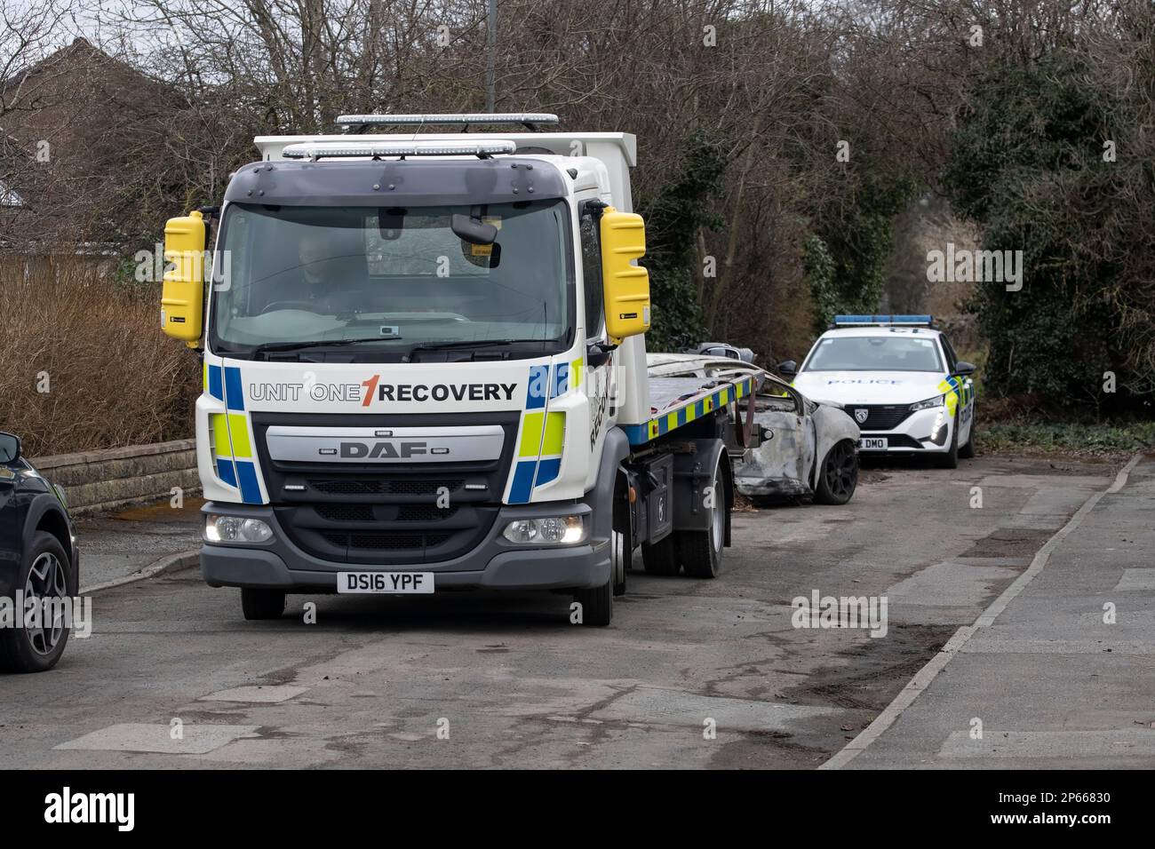 Ein von der Polizei beschlagnahmter DAF-Abschleppwagen soll in West Yorkshire eine illegal abgefackelte und verlassene Schale eines Wagens entfernen Stockfoto