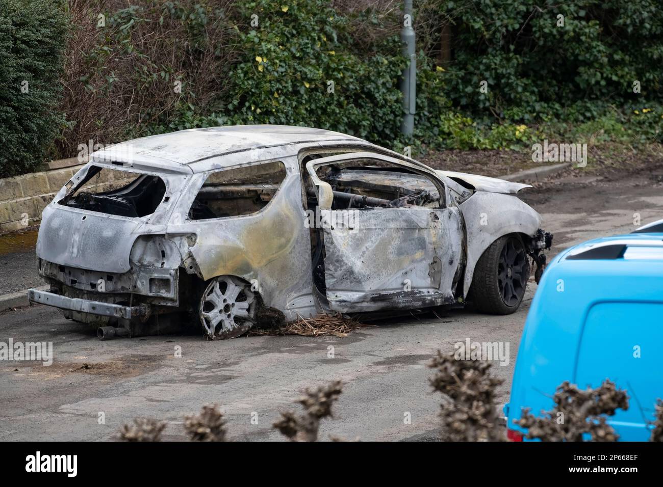 Die ausgebrannte Hülle eines gestohlenen Wagens, das von Vandalen angezündet wurde und in West Yorkshire auf Genesung wartet Stockfoto