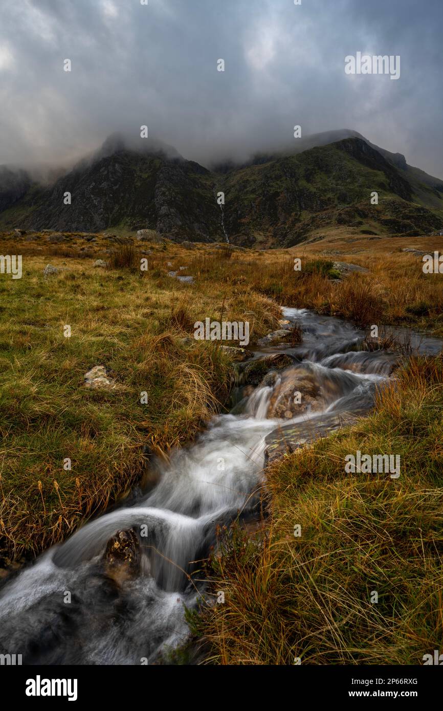 Kaskadenwasser im Nant Ffrancon Valley, das von Bergen, Snowdonia, Wales, Großbritannien und Europa umgeben ist Stockfoto