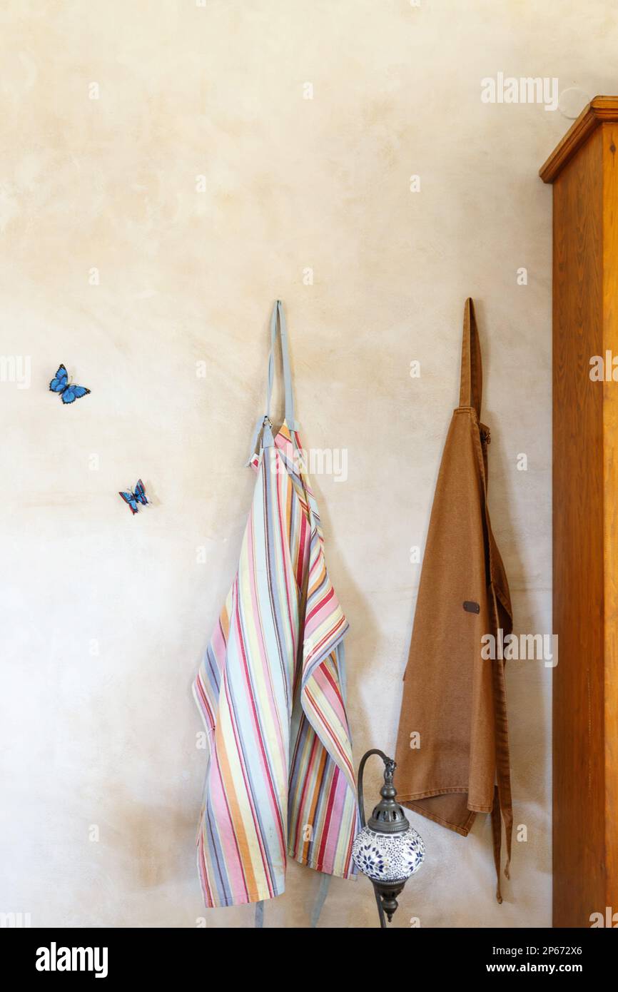 Schürze, Aufhängen und Kunsthandwerk oder Studio gegen Still Life Wall . Kreativität, Töpferei und Kleidung mit einer Gruppe Schürzen in einem kleinen Unternehmensgründungsunternehmen. Stockfoto