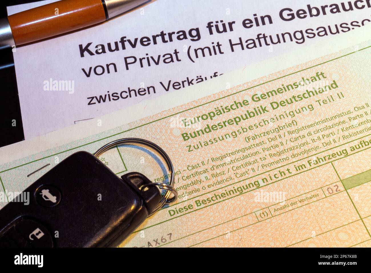 Symbolbild: Kaufvertrag für ein Auto mit Fahrzeugschein und Fahrzeugschlüssel (Deutschland) Stockfoto