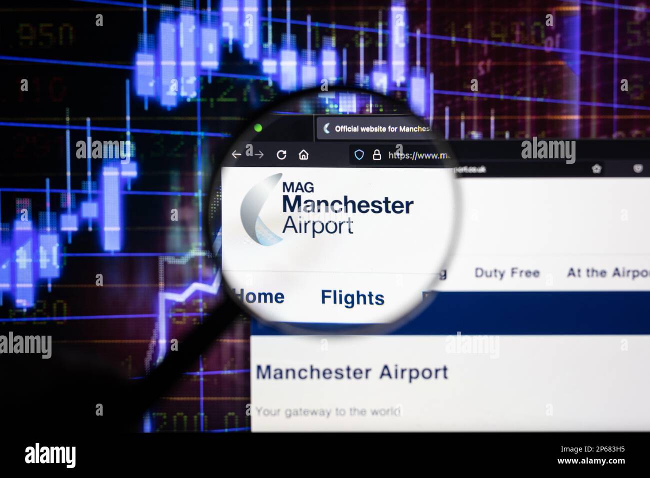 Firmenlogo des Flughafens Manchester auf einer Website mit verschwommenen Aktienmarktentwicklungen im Hintergrund, auf einem Computerbildschirm zu sehen Stockfoto