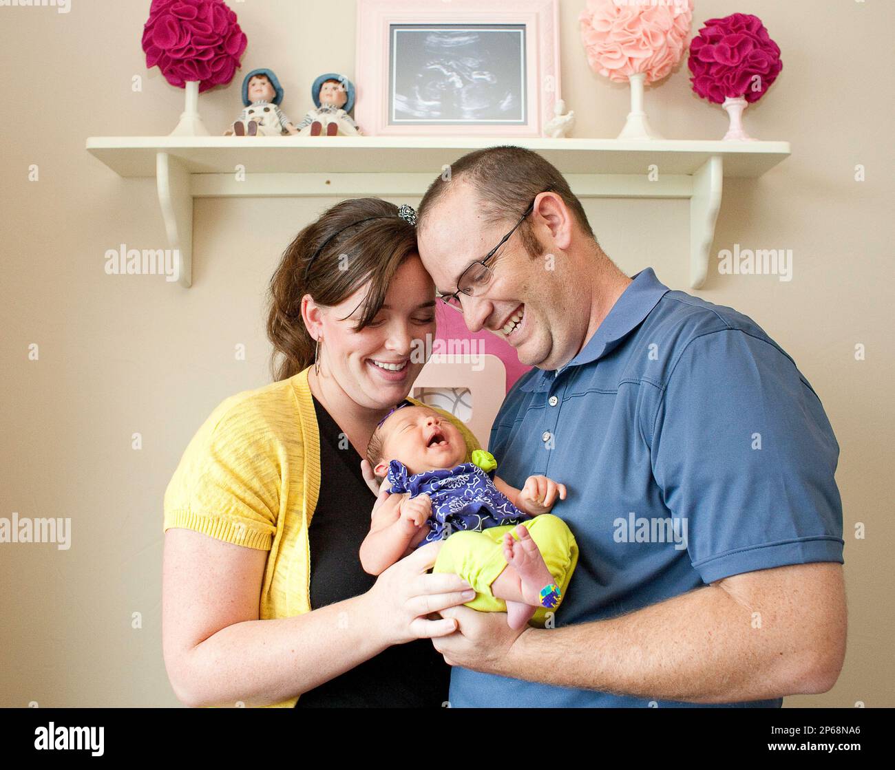 Kimberly Belnap, 29, left, and Brock Belnap 33, hold their newborn daughter Blakely at home on Friday, July 27, 2012 in Four Corners, Mont. The Belnaps had their first child through in vitro fertilization and gave birth to their newborn at Deaconess Hospital in Bozeman, Mont. (AP Photo/Bozeman Daily Chronicle, Adrian Sanchez-Gonzalez) Stockfoto