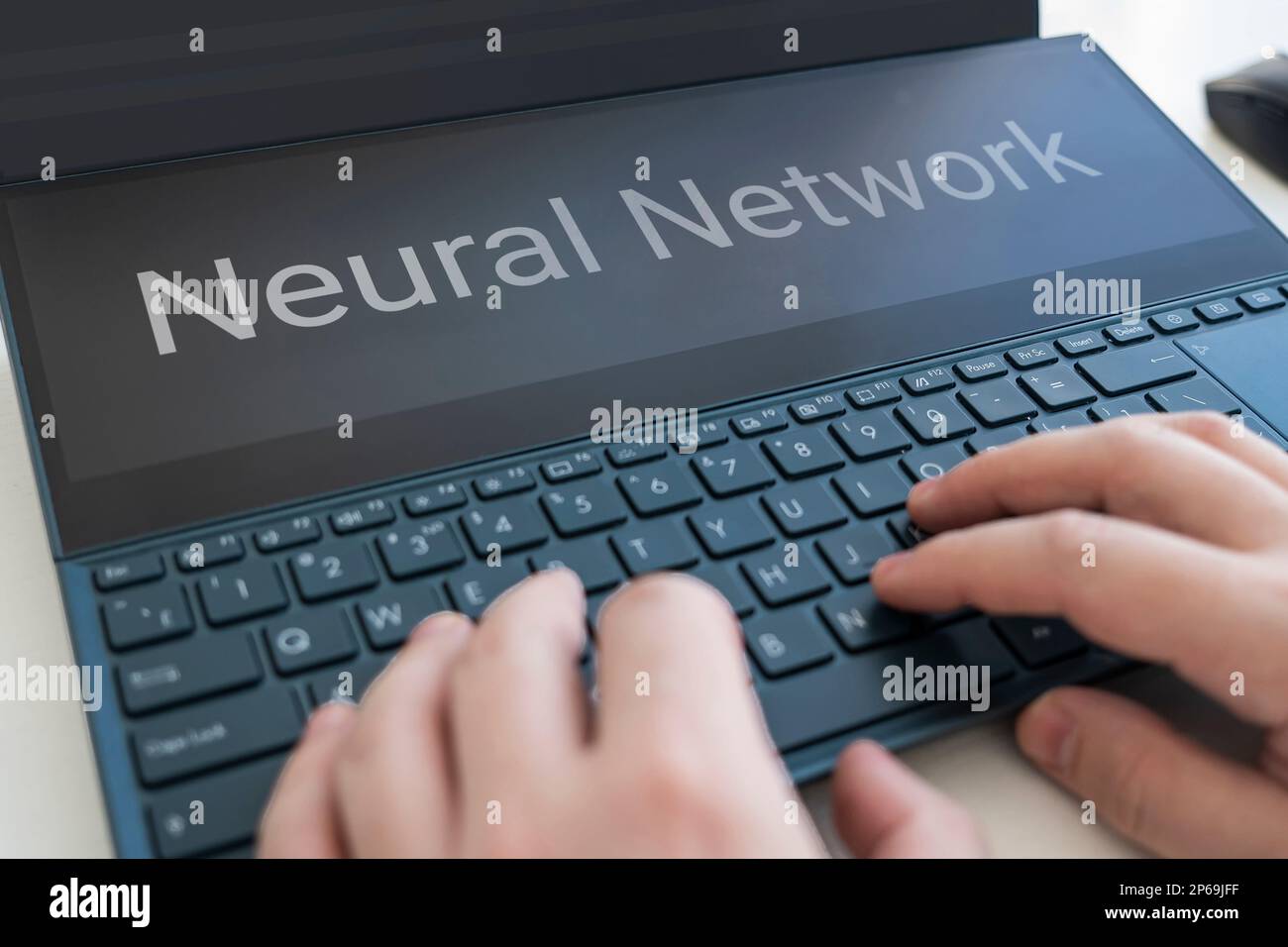 Die Hände tippen auf dem Laptop im Hintergrund. Neuronales Netzwerk und maschinelles Lernkonzept. Das Wort neuronales Netzwerk auf dem Laptop-Bildschirm. Künstlicher Intelligent Stockfoto