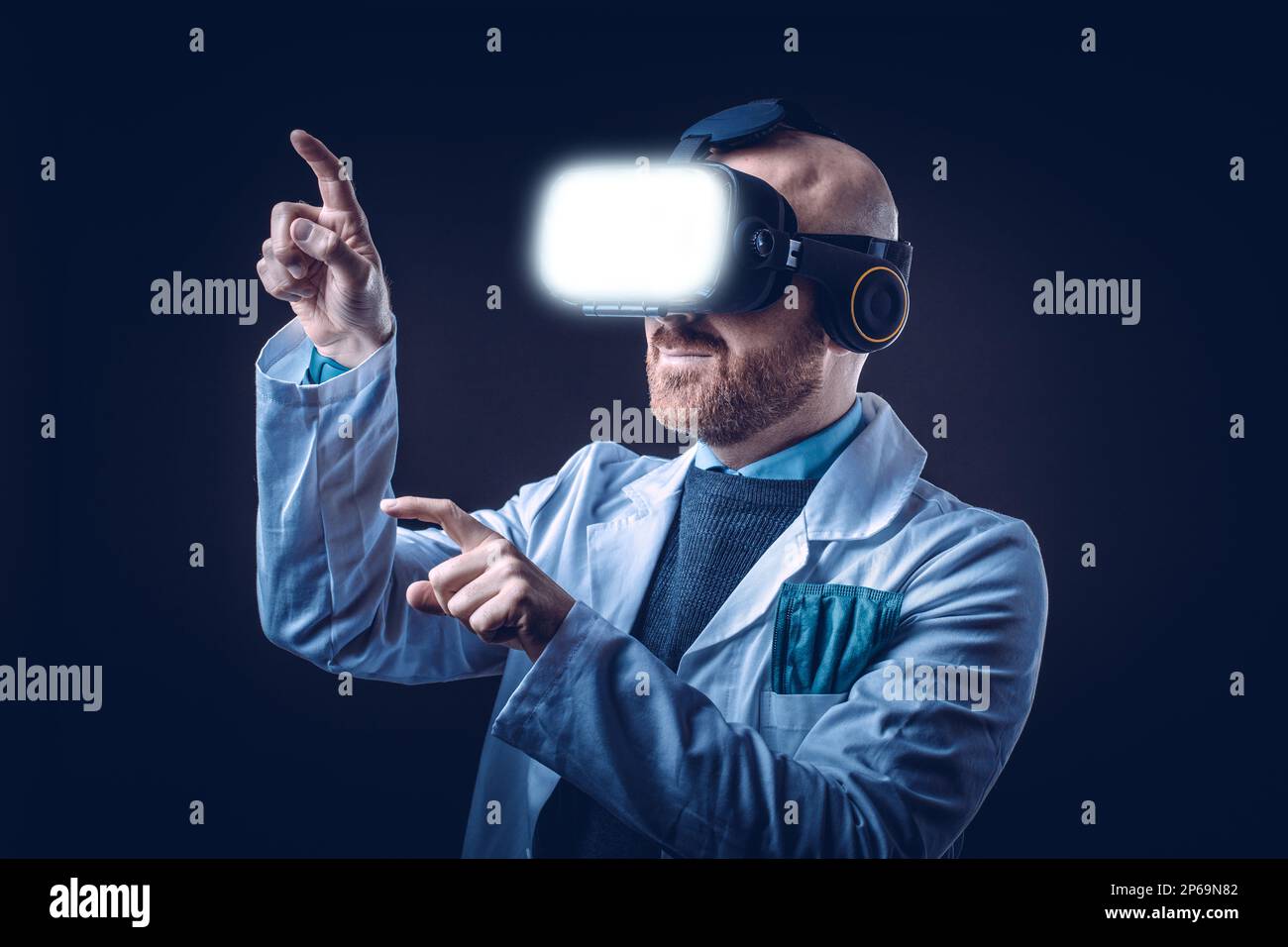 Foto eines männlichen Arztes mit 3D-Brille mit schwarzem Hintergrund und medizinischem weißem Kittel Stockfoto
