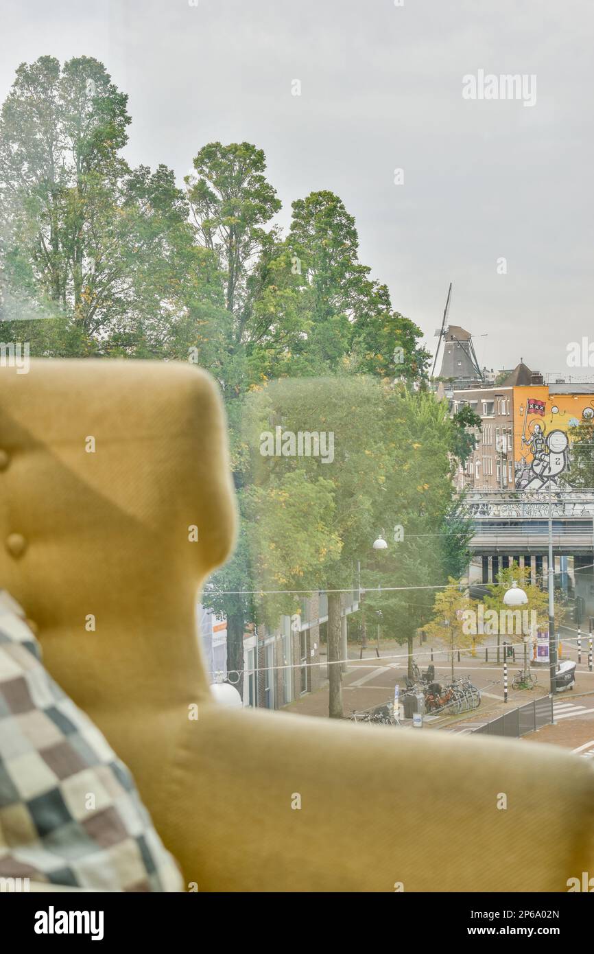 Ein Teddybär, der vor einem Fenster sitzt und auf die Sündenbären der Stadt blickt, ist sichtbar Stockfoto