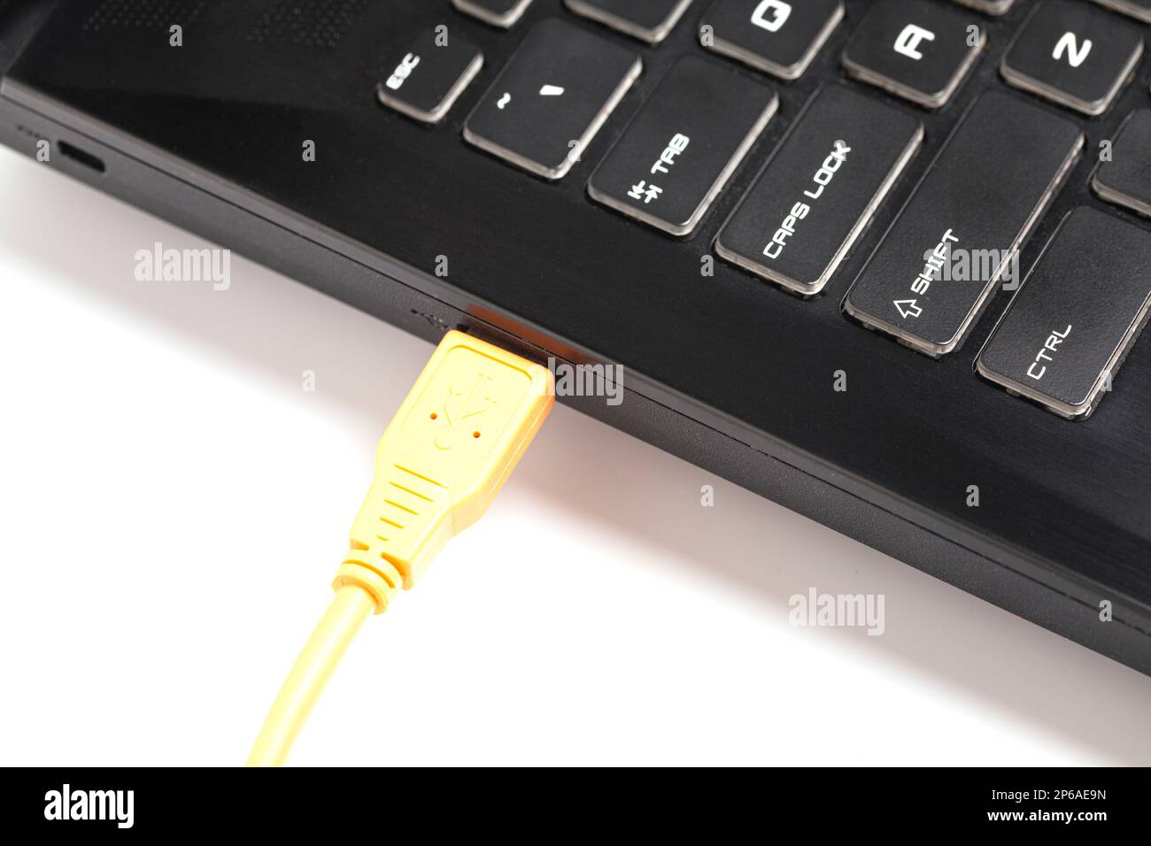 Laptop mit orangefarbenem USB-Kabel Stockfoto