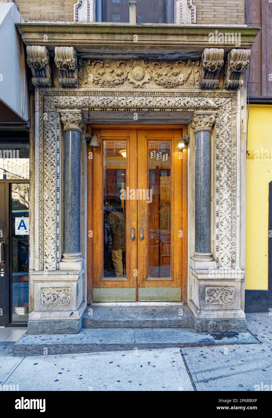 Weiße Terracotta schmückt die Elemente dieses mittelhohen Appartementgebäudes mit braunen römischen Backsteineineinwänden im Stadtviertel Murray Hill in Manhattan. Stockfoto