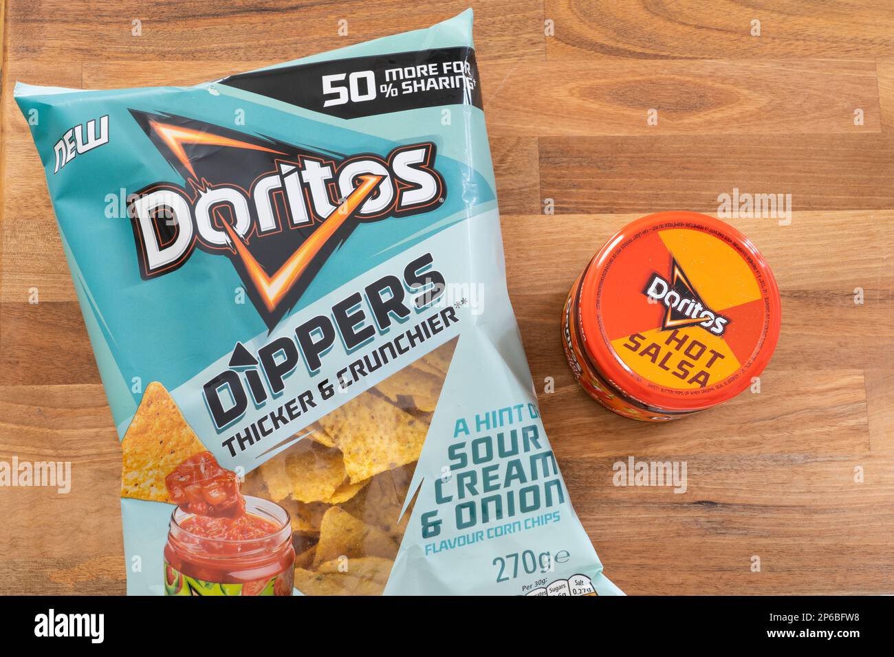 Doritos saure Sahne und Zwiebelchips (Chips) in einem Beutel mit einer heißen Salsa-Sauce von Doritos nebenan. UK. Thema: Snacks, Partyessen Stockfoto