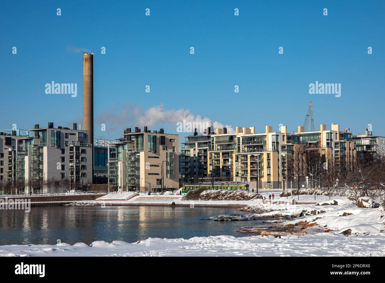 Schneebedeckte Strände von Eiran Ranta oder Eiranranta mit modernen Hernesaari-Wohngebäuden im Hintergrund an einem sonnigen Wintertag in Helsinki, Finnland Stockfoto