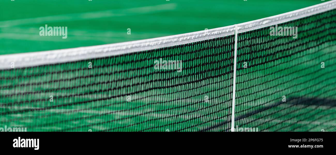 Grünes Paddle-Tennisnetz und Hartplatz. Horizontales Sport-Thema Poster, Grußkarten, Header, Website und App Stockfoto