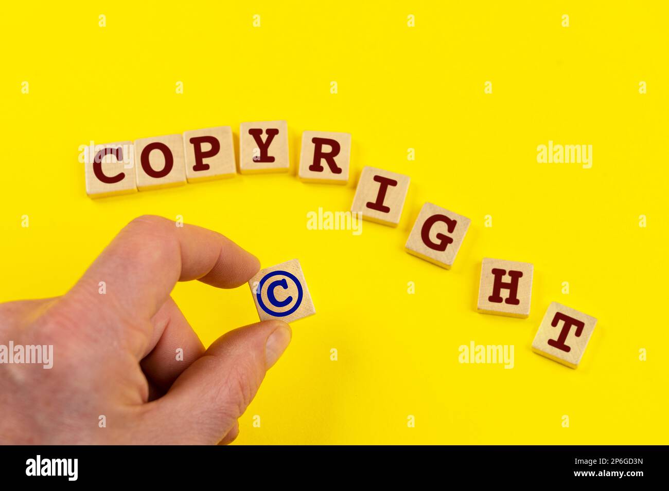 Das Wort Copyright, das sich aus kleinen Holztafeln auf einer farbigen Oberfläche gebildet hat Stockfoto