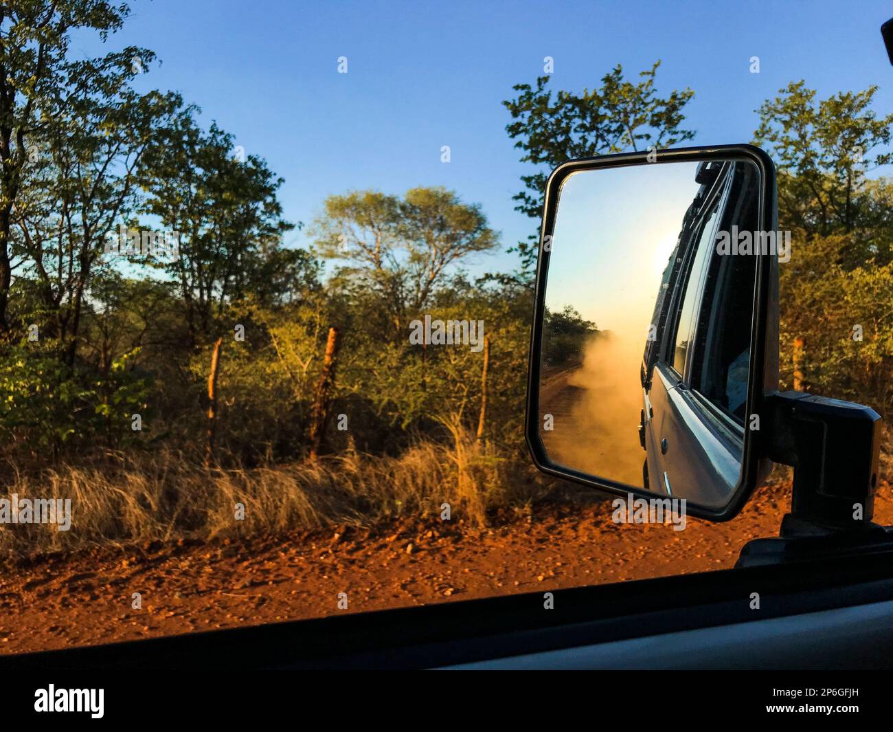 Die Reflexion im Rückspiegel des Fahrzeugs zeigt Staub, der in die Luft hinter dem Fahrzeug zirkuliert. Francistown, Botswana, Afrika Stockfoto