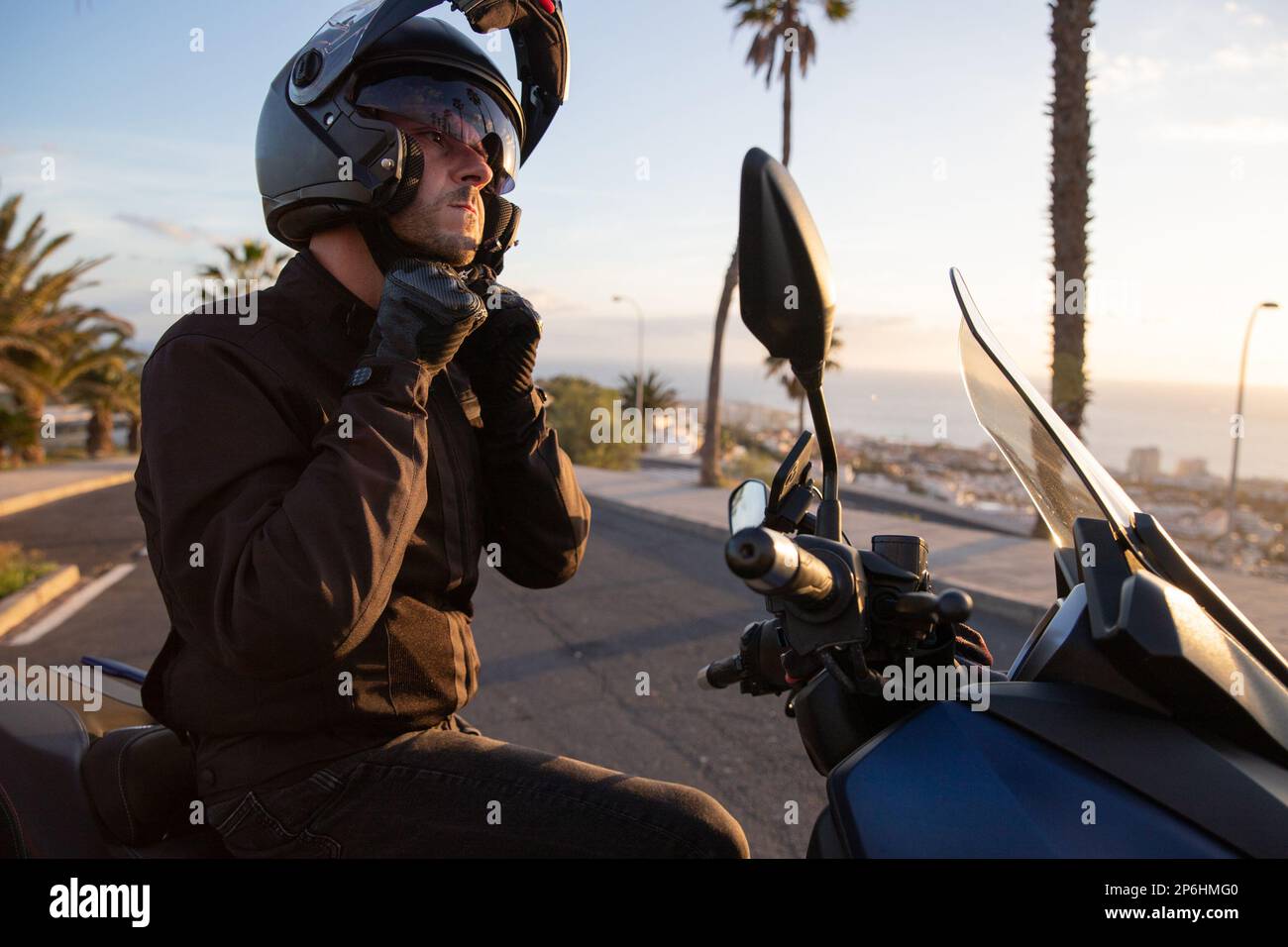 Ein Motorradfahrer, der auf seinem Motorrad sitzt, trägt einen Helm, um die Sicherheit des Fahrens zu gewährleisten. Stockfoto