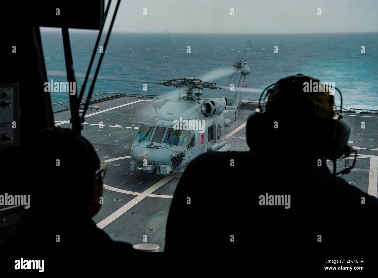 NATUNA SEA (26. Februar 2023) ein MH-60R SeaHawk, angeschlossen an Helicopter Maritime Strike Squadron (HSM) 35, bereitet sich auf den Start vom Cockpit des Küstenschiffes USS Oakland der Unabhängigkeitsklasse (LCS 24) während des Flugbetriebs vor, während das Schiff über die Natuna-See fährt, 26. Februar 2023. Oakland, Teil des Destroyer-Geschwaders 7, befindet sich in einem Rotationseinsatz und operiert im US-Flottengebiet 7., um die Interoperabilität mit Alliierten und Partnern zu verbessern und als einsatzbereite Eingreiftruppe zur Unterstützung einer freien und offenen Region Indo-Pazifik zu dienen. (USA Marinefoto von Mass Communication Specialis Stockfoto