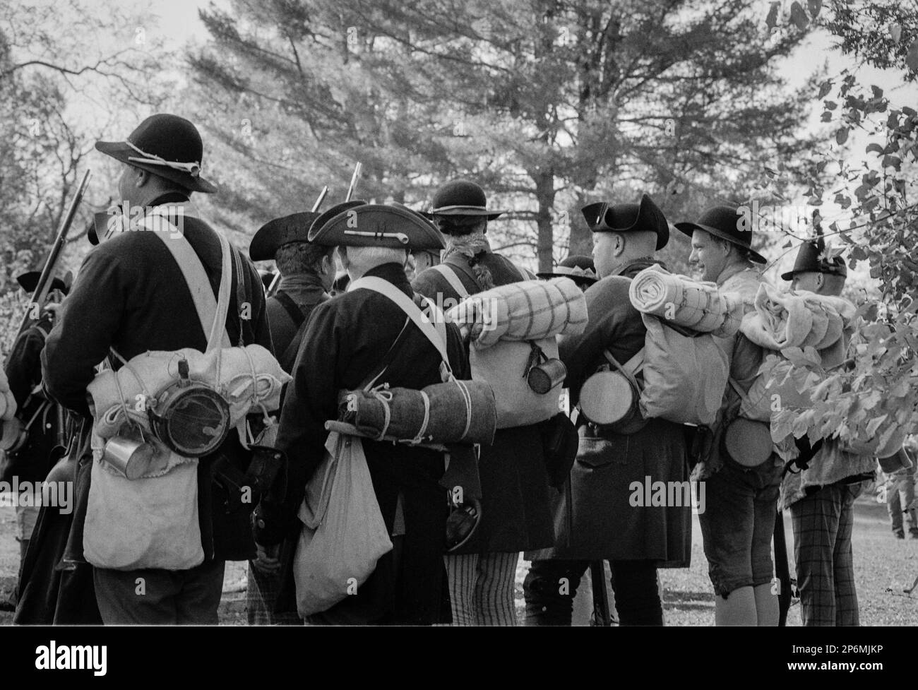Schauspieler/Soldaten in Kolonialuniformen stehen in Formation mit Rudeln auf dem Rücken und Musketen in der Hand während einer Nachstellung des Revolutionskrieges im Re Stockfoto