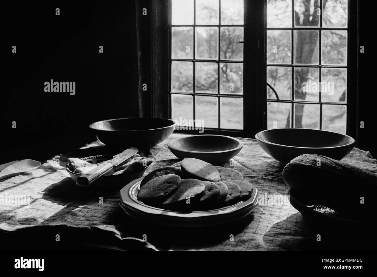 Teller mit frisch gebackenen Plätzchen und Brot, die während einer Nachstellung des Revolutionskriegs im Rebecca Nurse Homest auf einem Tisch vor einem Fenster ausgestellt wurden Stockfoto