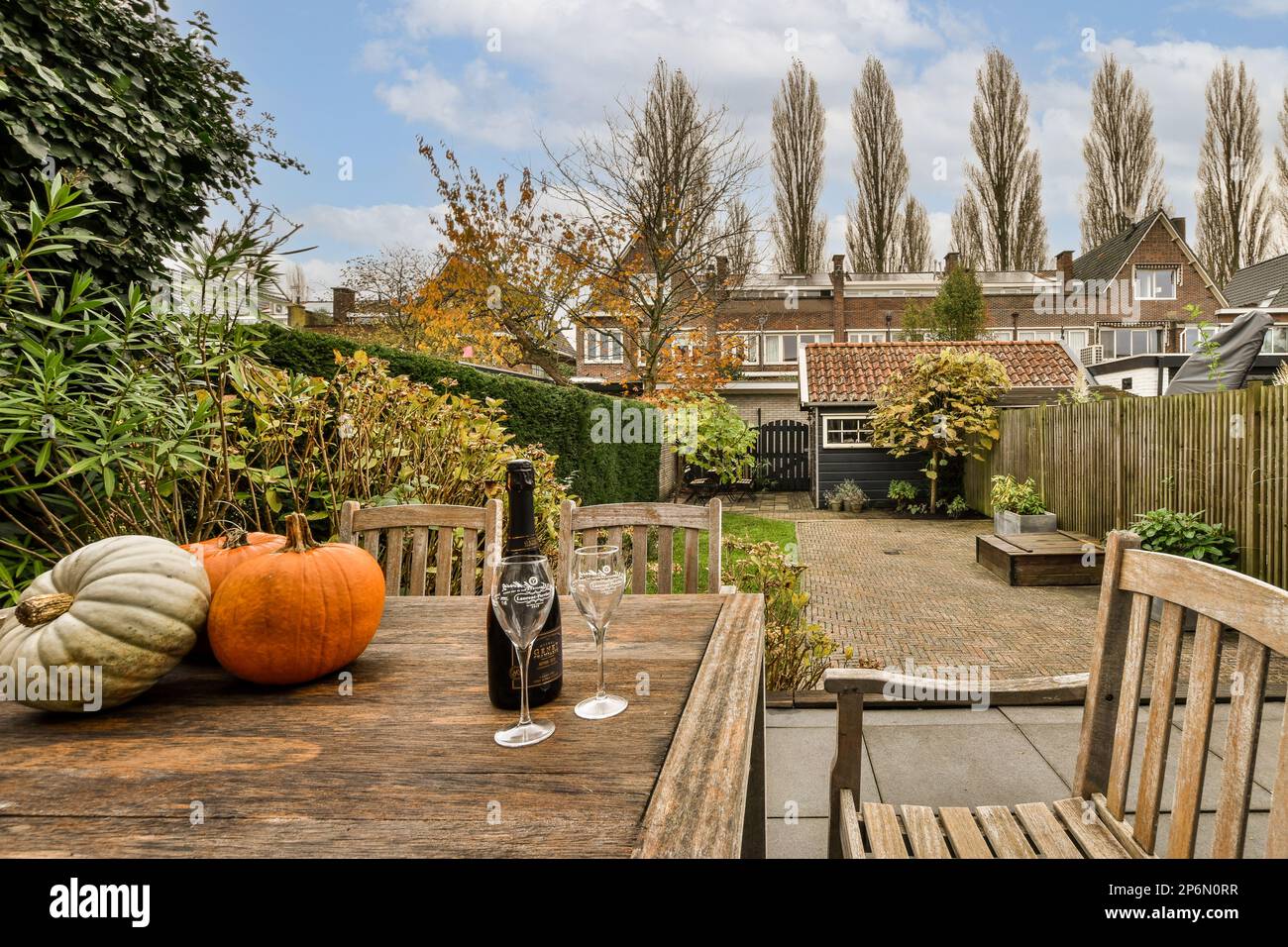 Amsterdam, Niederlande - 10. April 2021: Ein Tisch draußen mit ein paar Kürbissen und eine Flasche Wein neben dem Tisch im Hintergrund Stockfoto