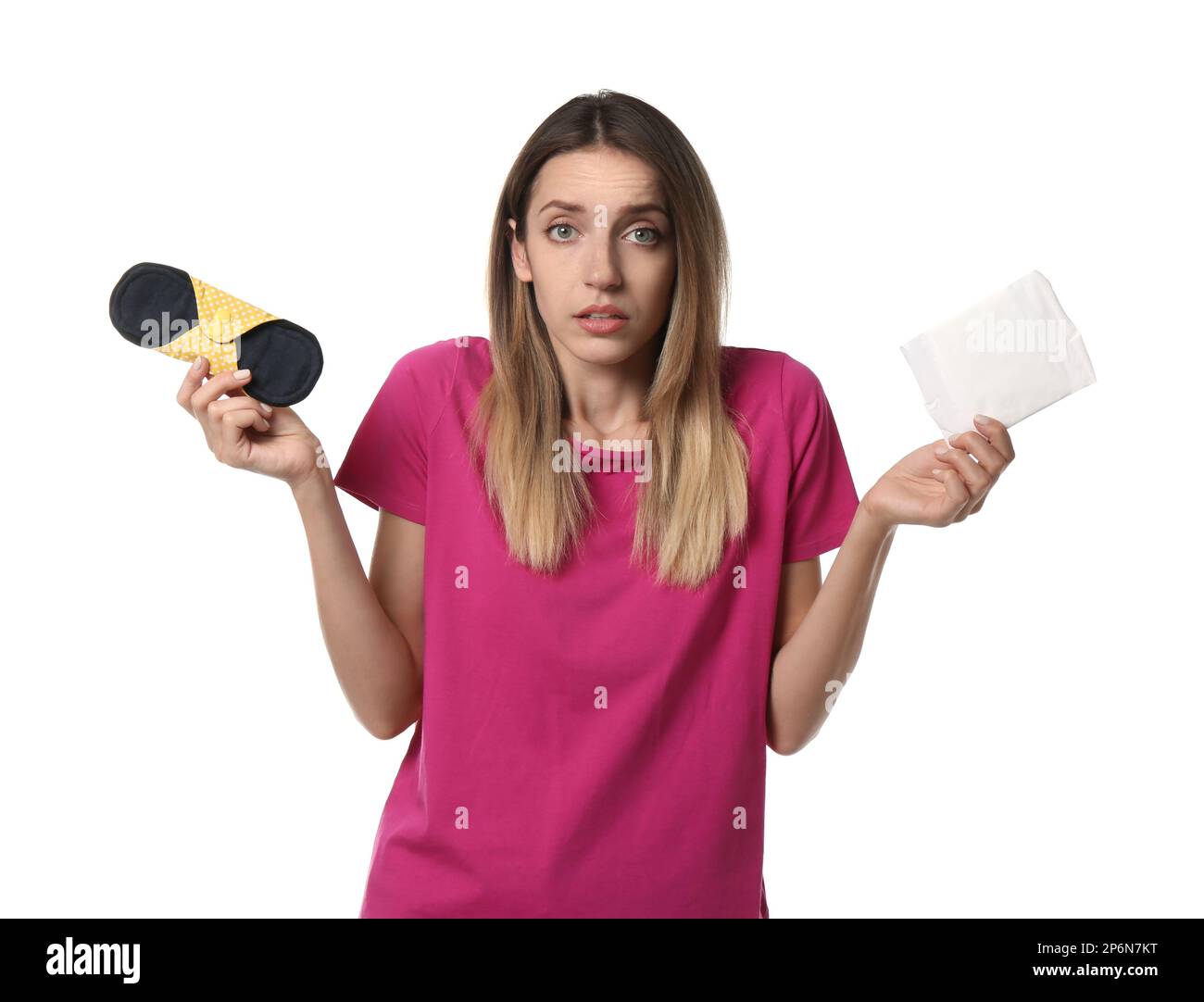 Verwirrte junge Frau mit Einweg- und Mehrweg-Stoffmenstruationseinlagen auf weißem Hintergrund Stockfoto