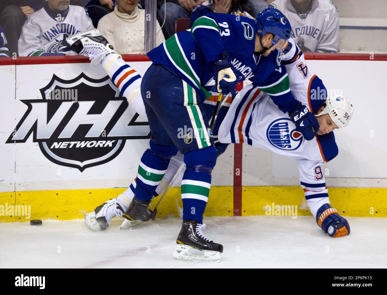 Vancouver Canucks' Alexander Edler, left, of Sweden, and Edmonton Oilers' Ryan Smyth collide during the second period of an NHL hockey game in Vancouver, British Columbia, on Tuesday, Jan. 24, 2012. (AP Photo/The Canadian Press, Darryl Dyck) Stockfoto