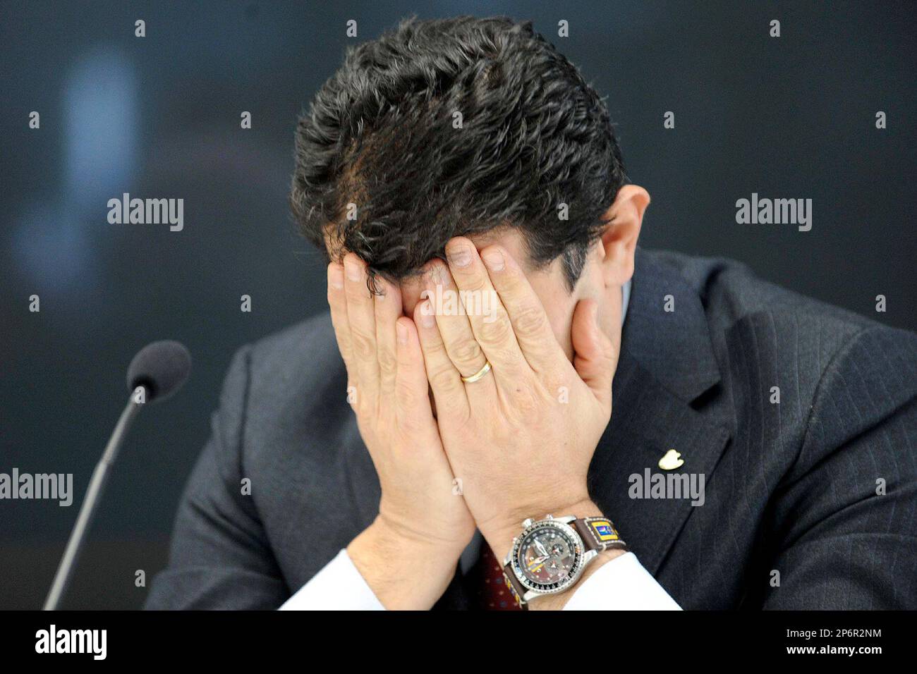 Costa Crociere general director Gianni Onorato covers his face during a news conference in Genoa, Italy, Monday, Jan. 16, 2012. The captain of the cruise ship that capsized off Tuscany made an unauthorized, unapproved deviation from the ship's programmed course, a "human error" that led to the grounding of the vessel, the chief executive of ship's Italian owner said Monday. The comments from Costa Crociere chairman and CEO Pier Luigi Foschi ramped up the pressure on the captain, who already is under investigation by authorities for suspected manslaughter and as well as allegations he abandoned Stockfoto