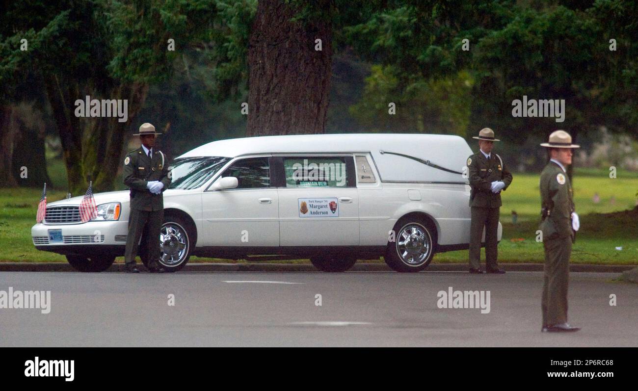 National Park Service rangers guard the hearse carrying the body of