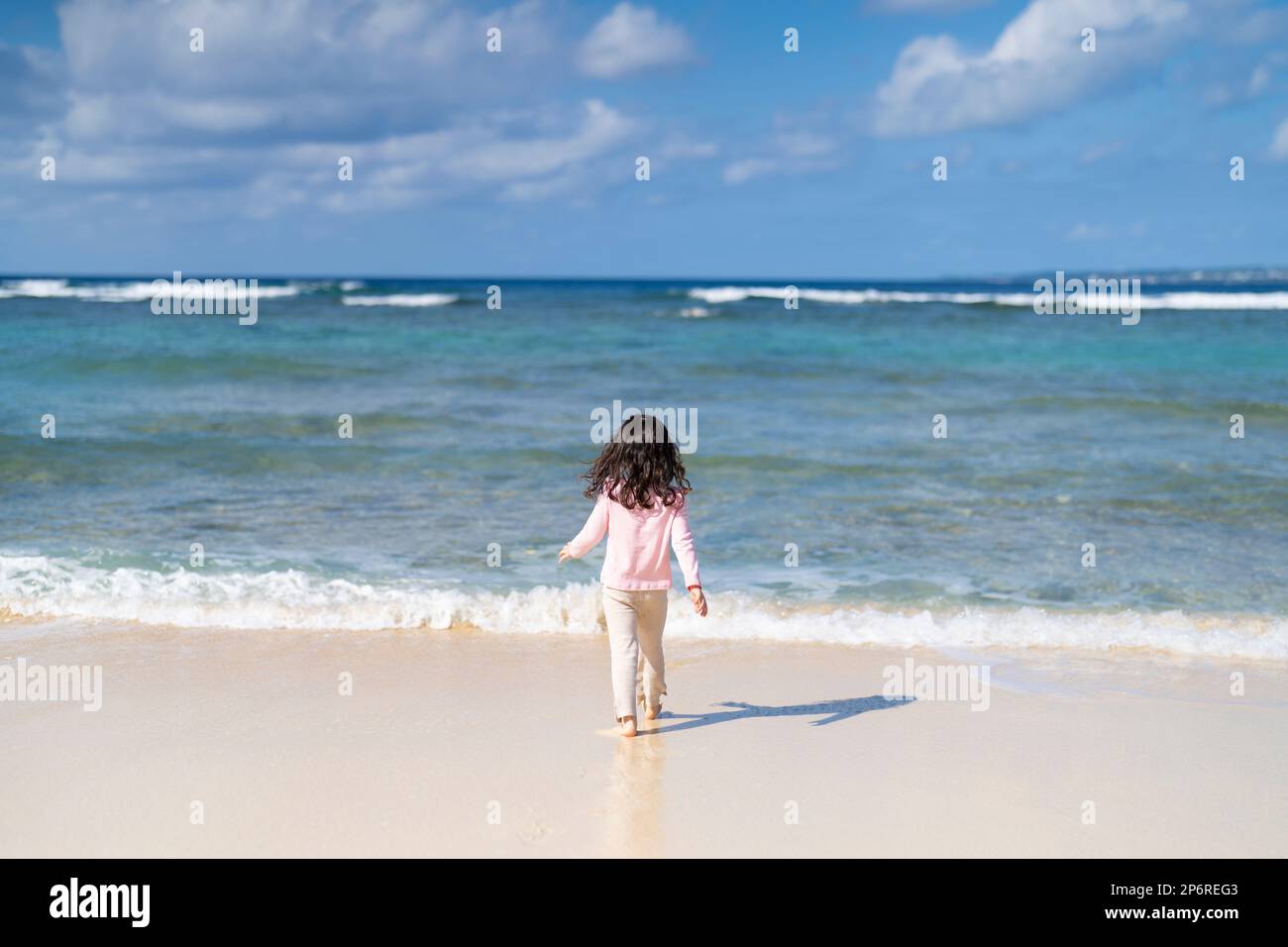 Ein junges Mädchen, das den Strand in Okinawa, Japan, erkundet Stockfoto