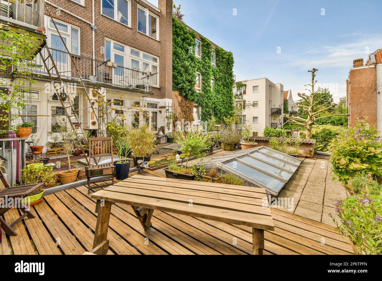 Amsterdam, Niederlande - 10. April 2021: Ein Außenbereich mit Holzmöbeln und Pflanzen im Vordergrund - Bild von oben, aber nicht klar Stockfoto