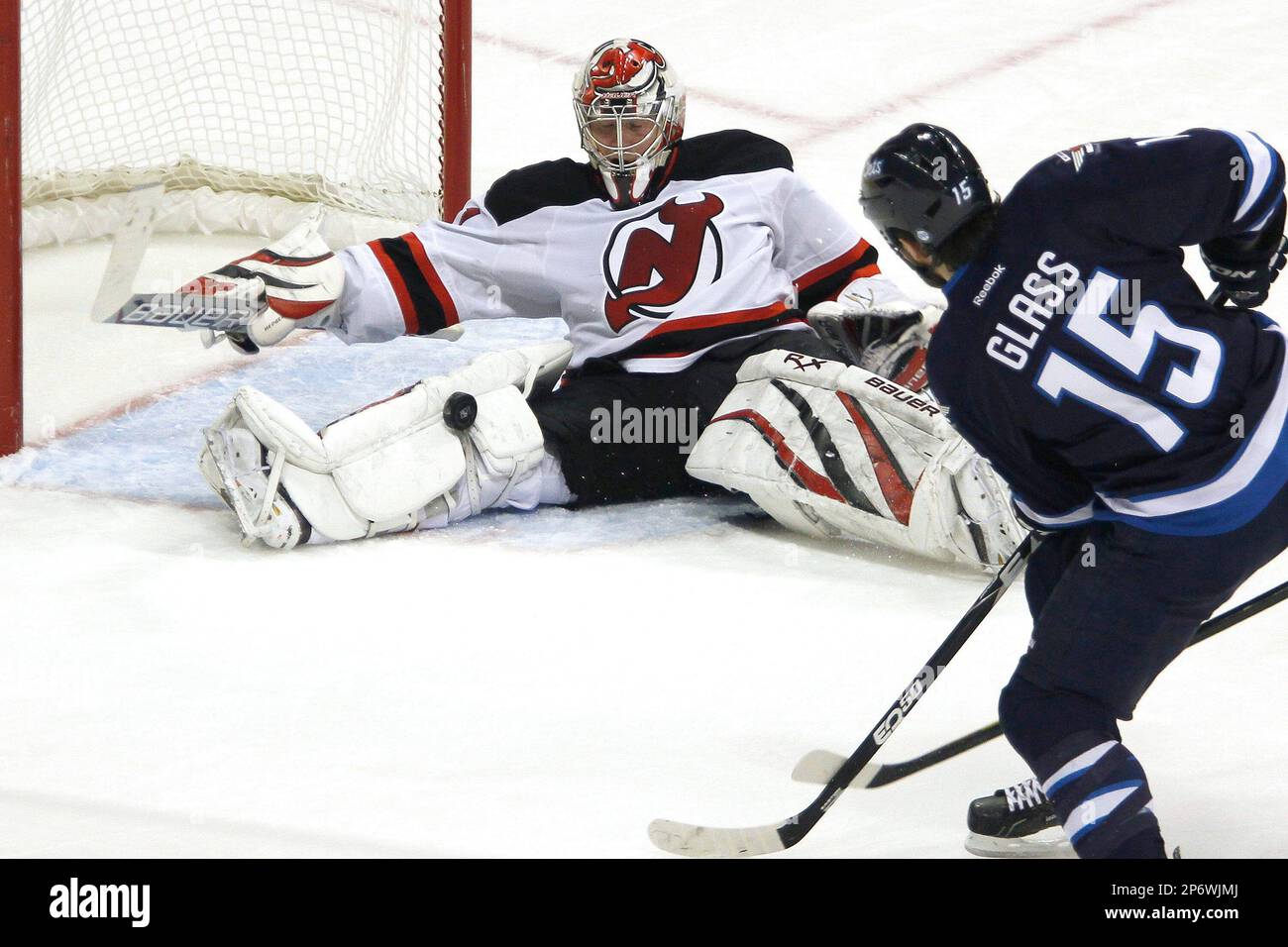 New Jersey Devils goaltender Johan Hedberg (1) stops a shot from Winnipeg Jets forward Tanner Glass (15) during the first period of an NHL hockey game, Saturday, Dec. 3, 2011, in Winnipeg, Manitoba. (AP Photo/The Canadian Press, John Woods) Stockfoto