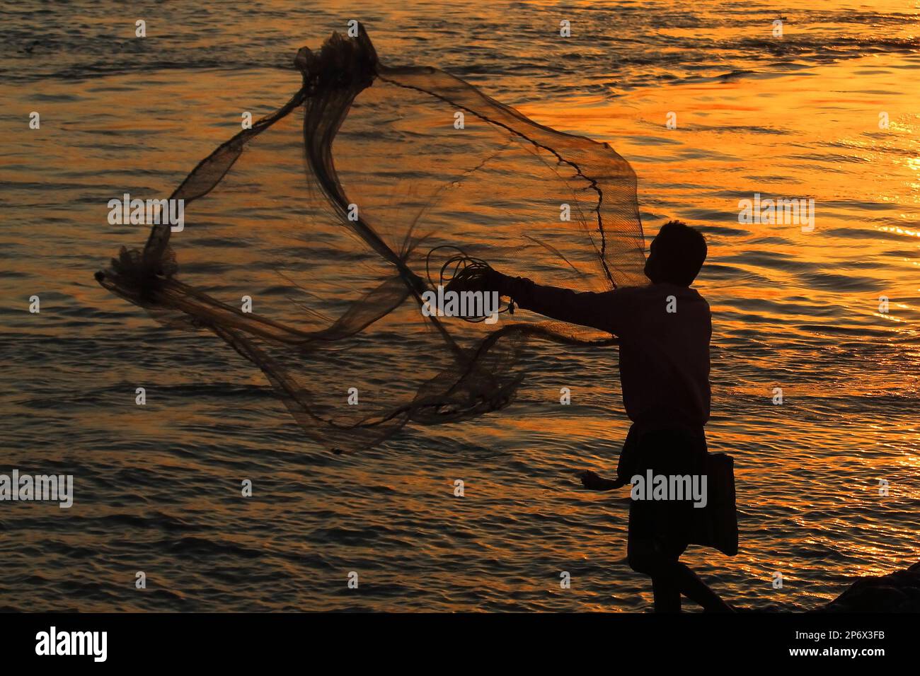 Netzfischen auf dem ganges bei Sonnenuntergang, ländliche Lebensweise indiens Stockfoto