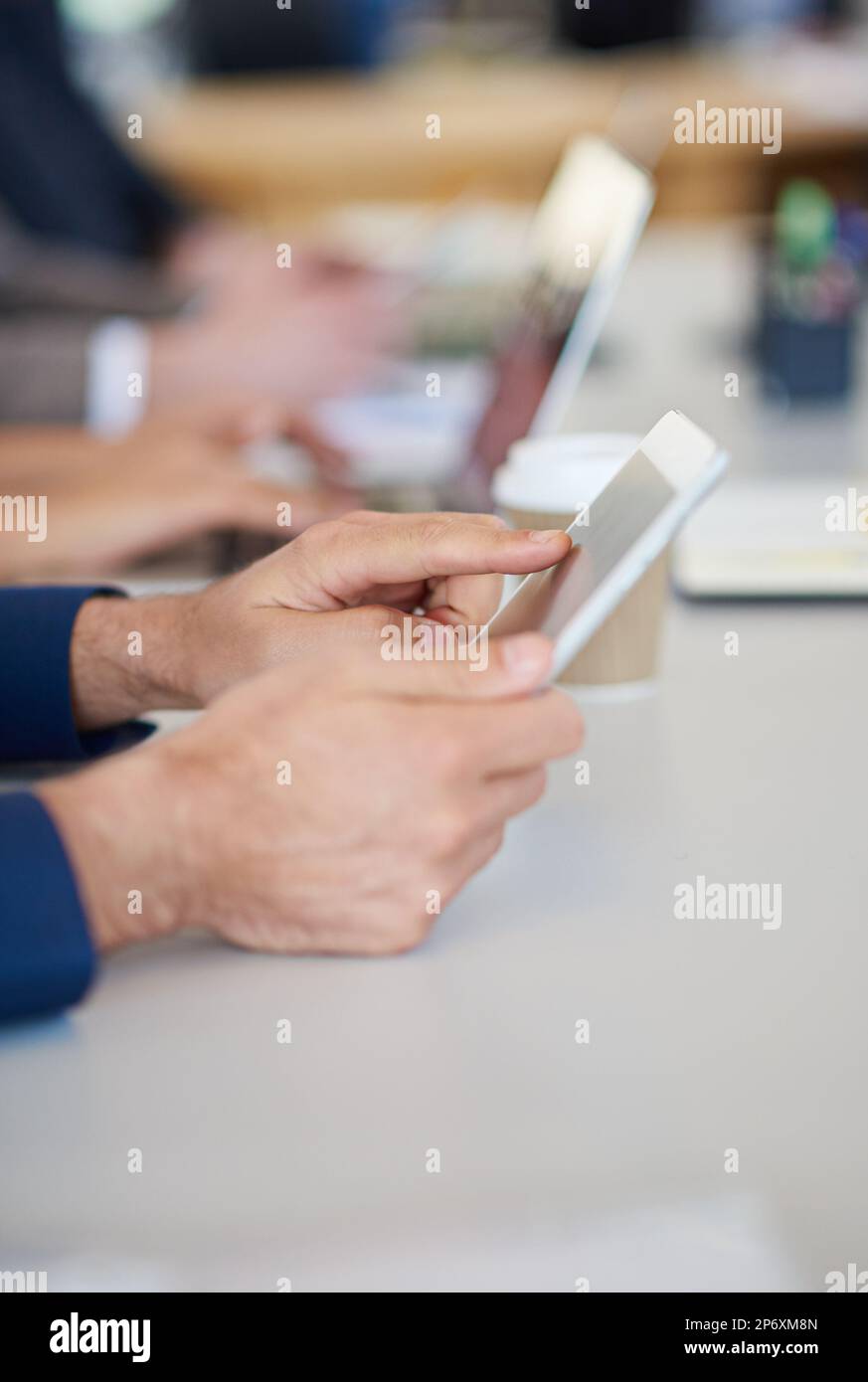 Vollkommene Touchscreen-Technologie. Eine Gruppe von Geschäftsleuten, die in einer Besprechung am Tisch sitzen und moderne Technologie nutzen. Stockfoto