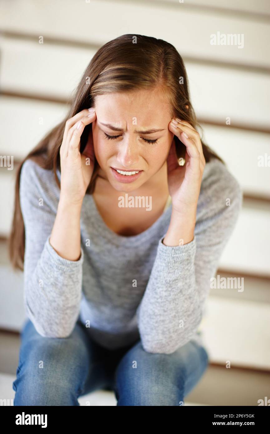 Ich bin von Idioten umgeben. Eine unglückliche junge Frau, die auf einer Treppe sitzt. Stockfoto