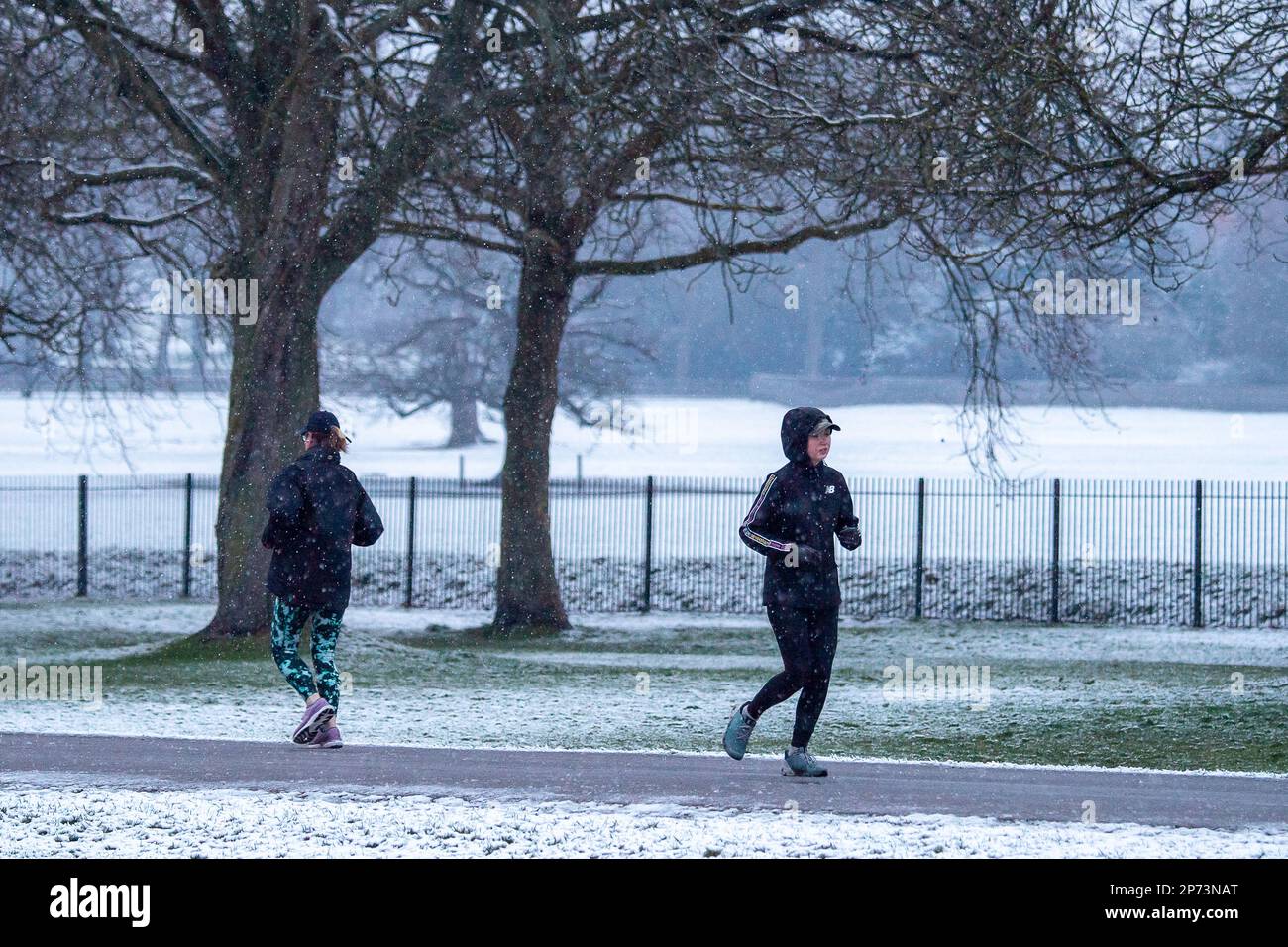 Windsor, Berkshire, Großbritannien. 8. März 2023. Wanderer und Jogger waren bei Tagesanbruch auf dem langen Spaziergang in Windsor nach nächtlichem Schnee draußen. Der Schnee begann sich zu Schneeregen zu verwandeln. Für morgen wird starker Regen vorhergesagt, und die Temperaturen bleiben kalt. Kredit: Maureen McLean/Alamy Live News Stockfoto