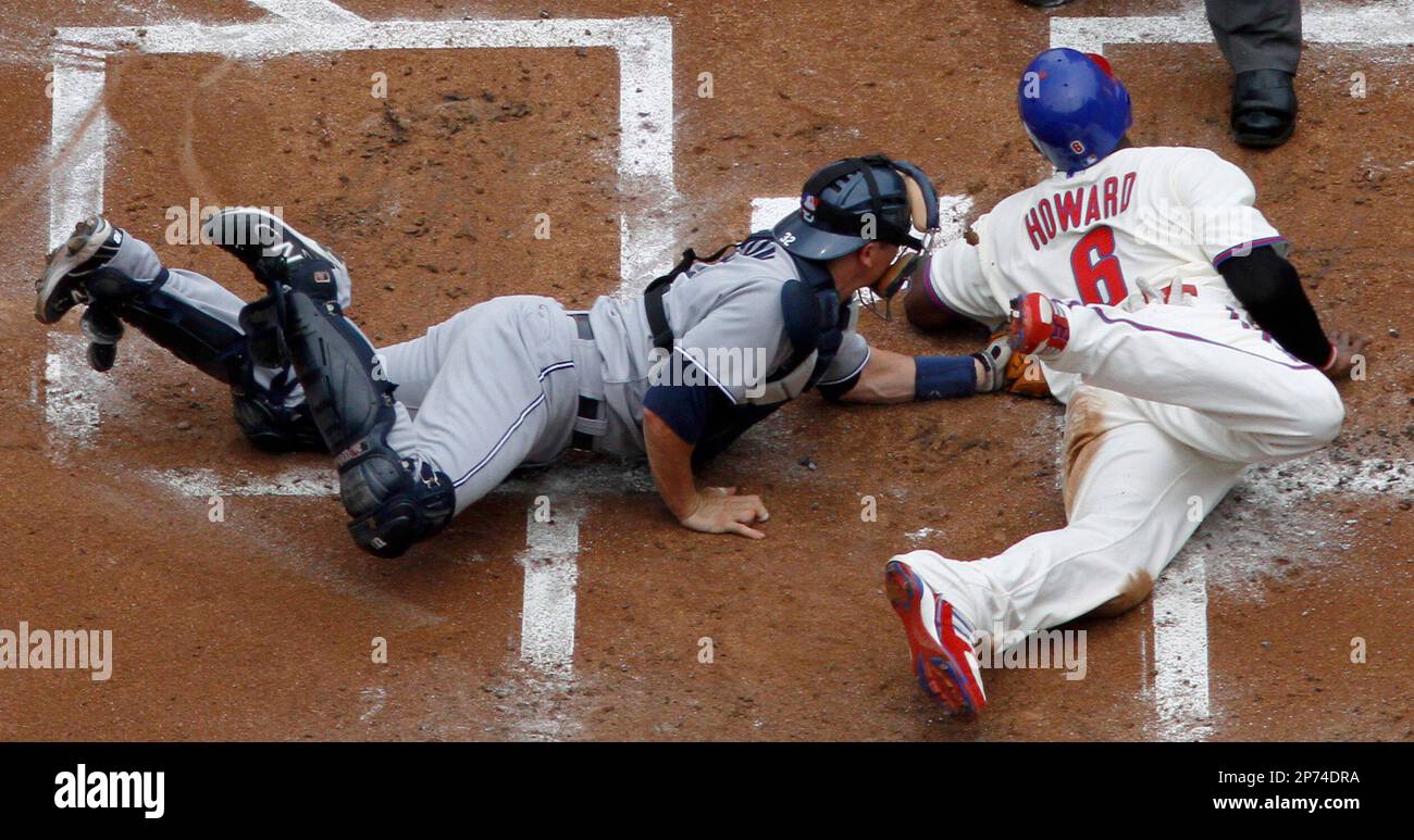 Philadelphia Phillies' Ryan Howard, right, is tagged out at home plate by San Diego Padres catcher Rob Johnson while trying to score on a double by Shane Victorino in the first inning of a baseball game Monday, July 25, 2011, in Philadelphia.(AP Photo/Matt Slocum) Stockfoto