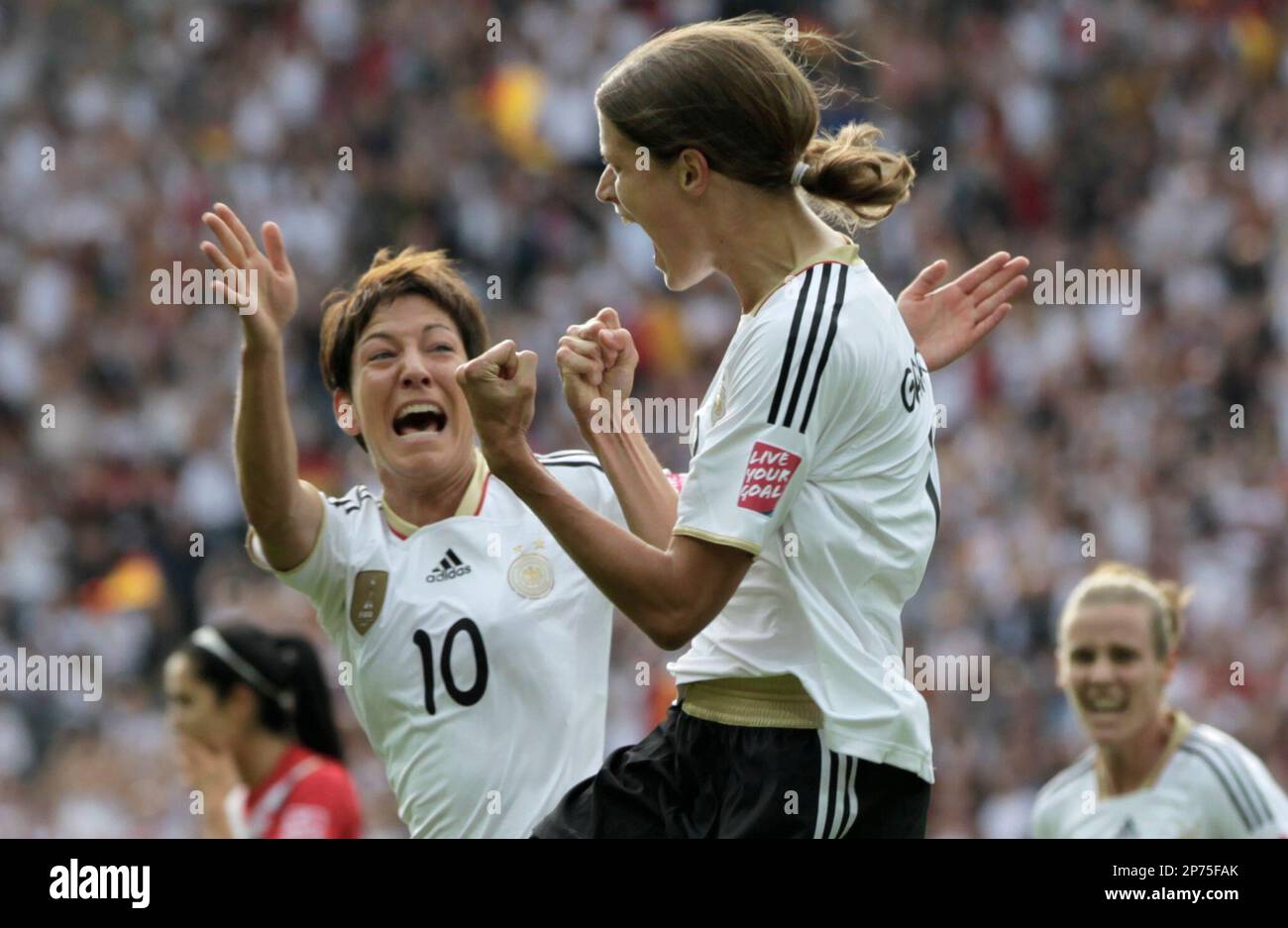 Germany's Kerstin Gareferekes is congratulated by Germany's Linda Bresonik, left, as she celebrates scoring the opening goal during the group A match between Germany and Canada at the Women’s Soccer World Cup in Berlin, Germany, Sunday, June 26, 2011. (AP Photo/Gero Breloer) Stockfoto