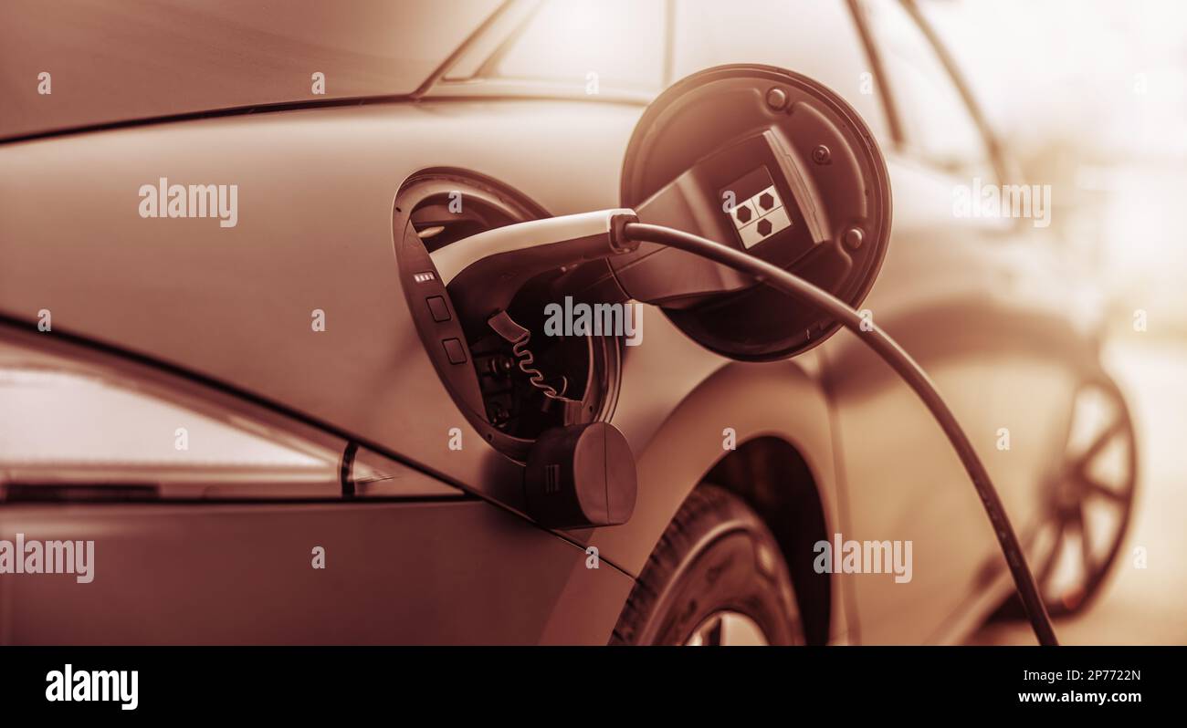 Nahaufnahme des angeschlossenen Steckers zum Elektrofahrzeug. Stockfoto