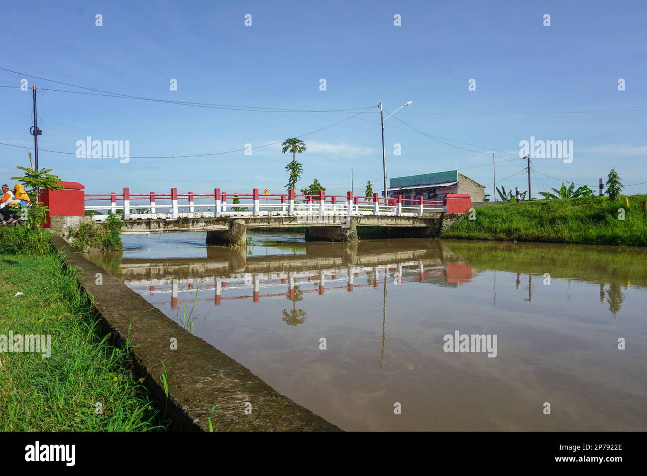 Kleine Dorfbrücke, die den Fluss überquert Stockfoto