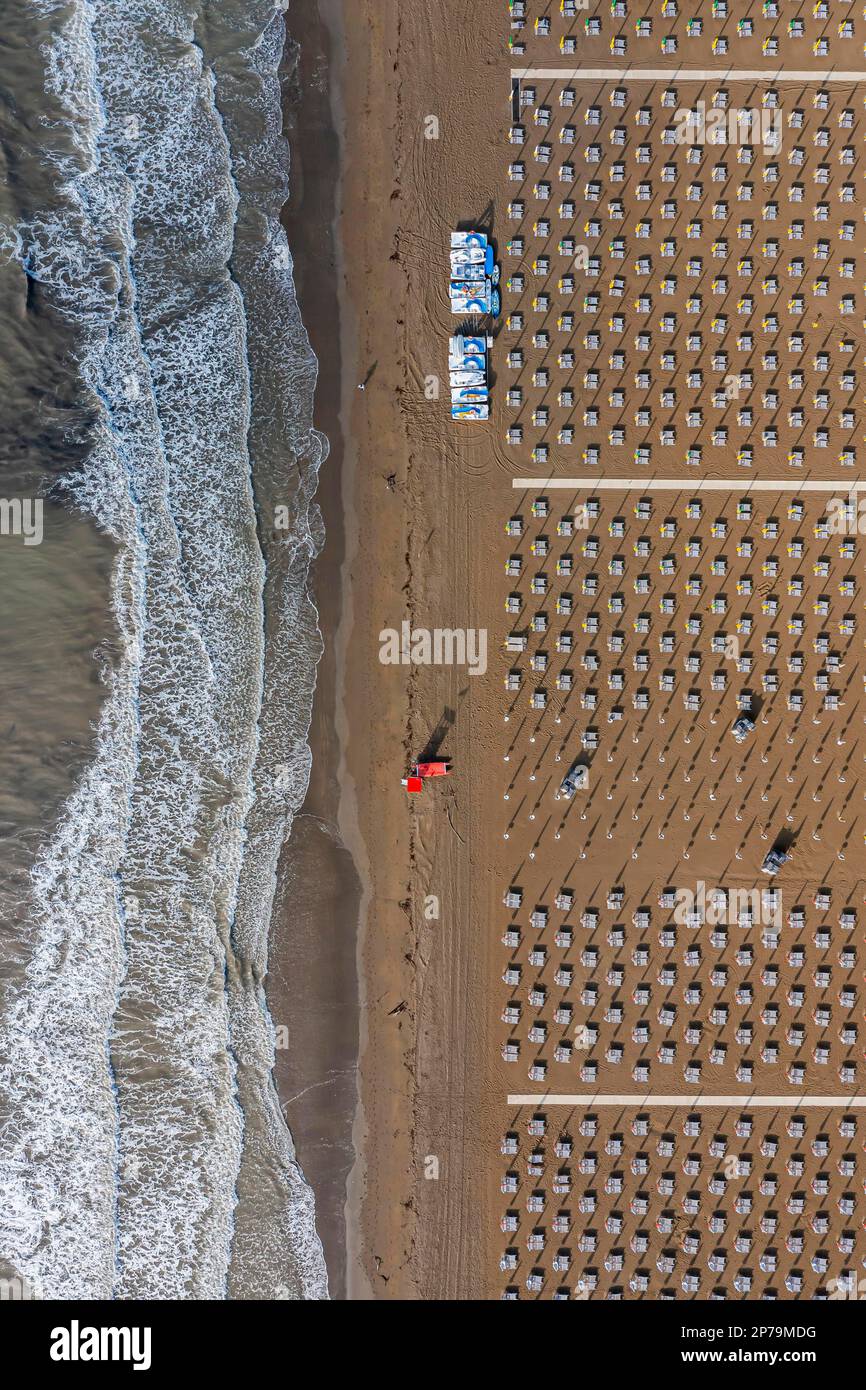 Feiner Sandstrand an der Adria, frühmorgendlicher Drohnenschuss mit korrekt platzierten Liegestühlen, Caorle, Veneto, Italien Stockfoto