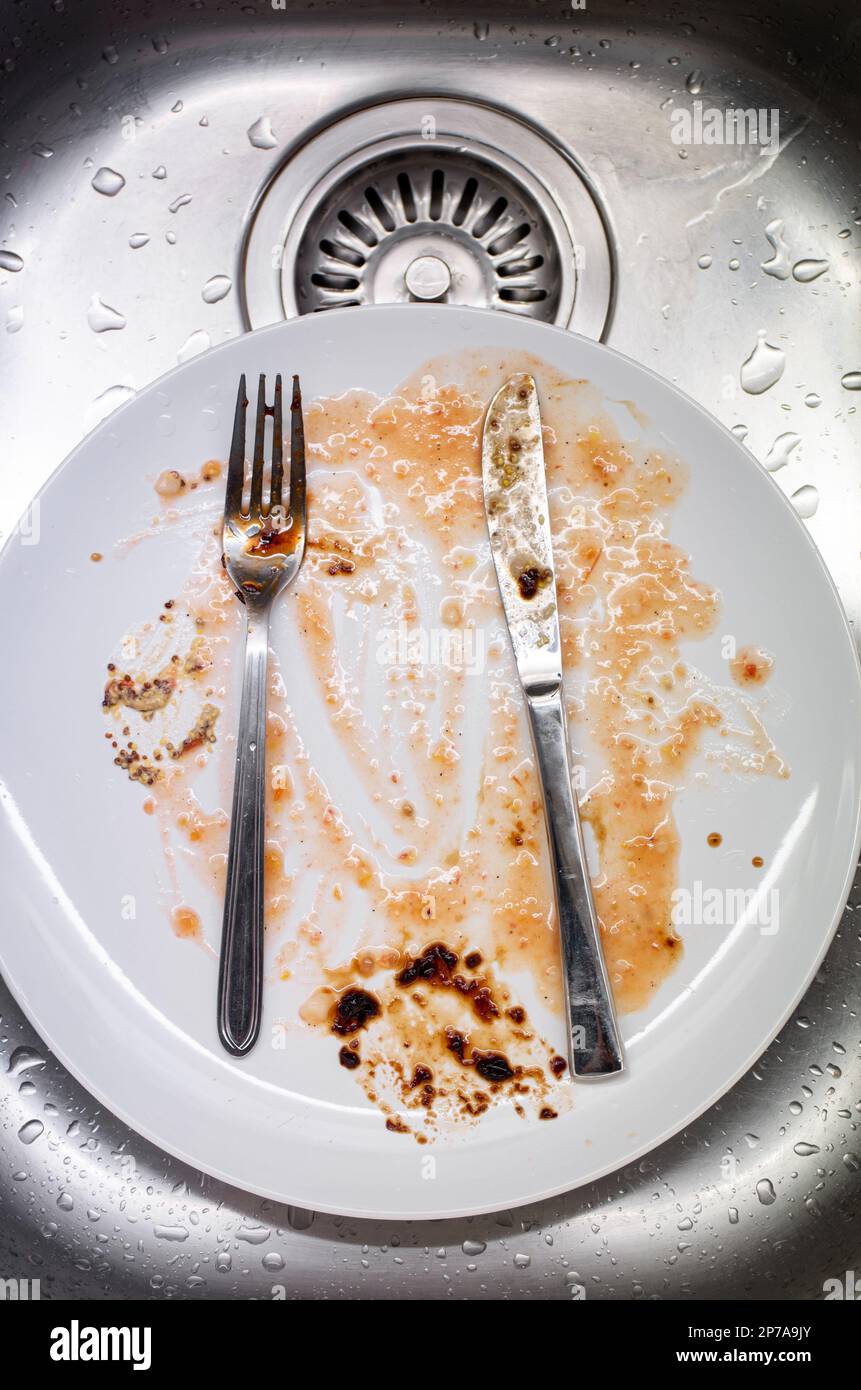 Dreckiges Geschirr im Waschbecken. Porzellangeschirr und Utensilien mit Essenssoße, keine Menschen, Top-Aussicht. Stockfoto