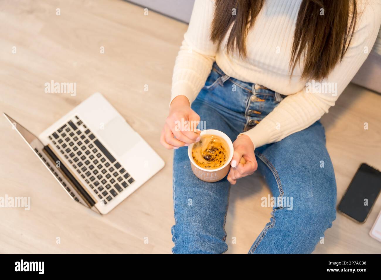 Hände einer Frau mit Computer, die auf einem Sofa mit heißem Kaffee sitzt, Millennials, soziale Medien, Blog Stockfoto