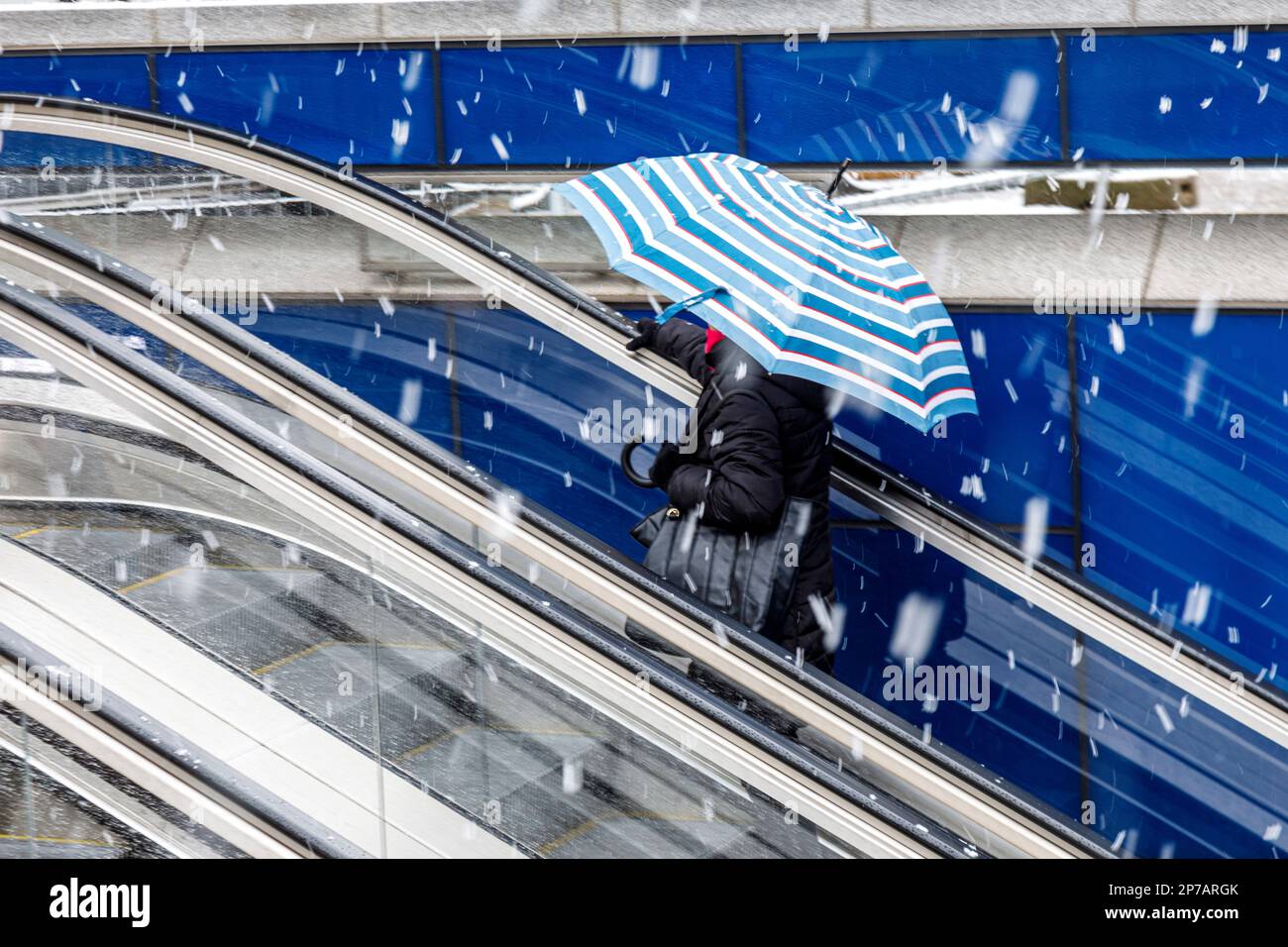 Passanten mit Schirm von der U-Bahn in den Schneesturm Stockfoto
