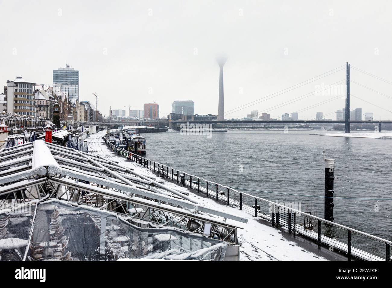 Düsseldorf im Schnee, Rheinpromenade in Richtung Hafen und Rheinturm Stockfoto