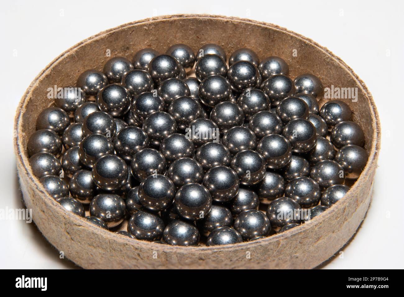 Stapel neuer Metallkugellager in einem Karton. Nahaufnahme des Studios, isoliert auf Weiß. Stockfoto