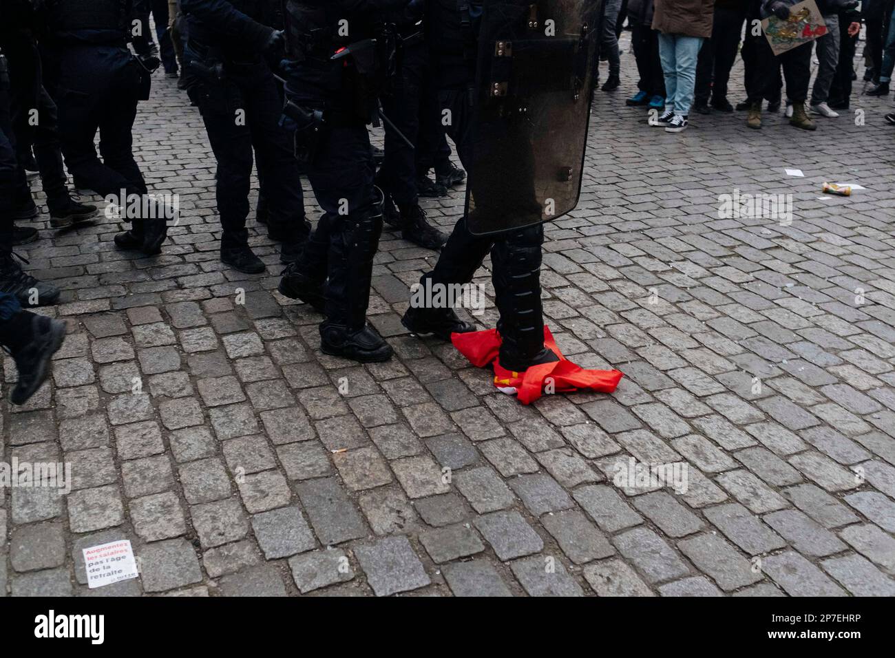 Frankreich / Paris / 07/03/2023, Jan Schmidt-Whitley/Le Pictorium - Demonstration gegen die Rentenreform in Paris - 7/3/2023 - Frankreich / Paris / Paris - Ein Polizist trampelt mit einer CGT-Flagge. Selbst wenn die Zahl der Streikenden nicht die Werte für Januar erreichte, begrüßten die Gewerkschaften am Dienstag, dem 7. März, eine "historische Mobilisierung" während der Demonstrationen, bei denen laut dem Innenministerium 1,28 Millionen Menschen in Frankreich und laut der CGT 3,5 Millionen Menschen zusammenkamen. Stockfoto