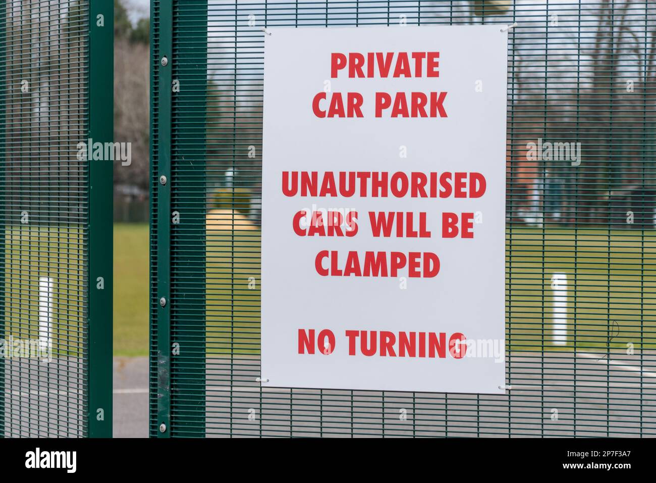 Schild: Privater Parkplatz, nicht autorisierte Autos werden festgeklemmt Stockfoto