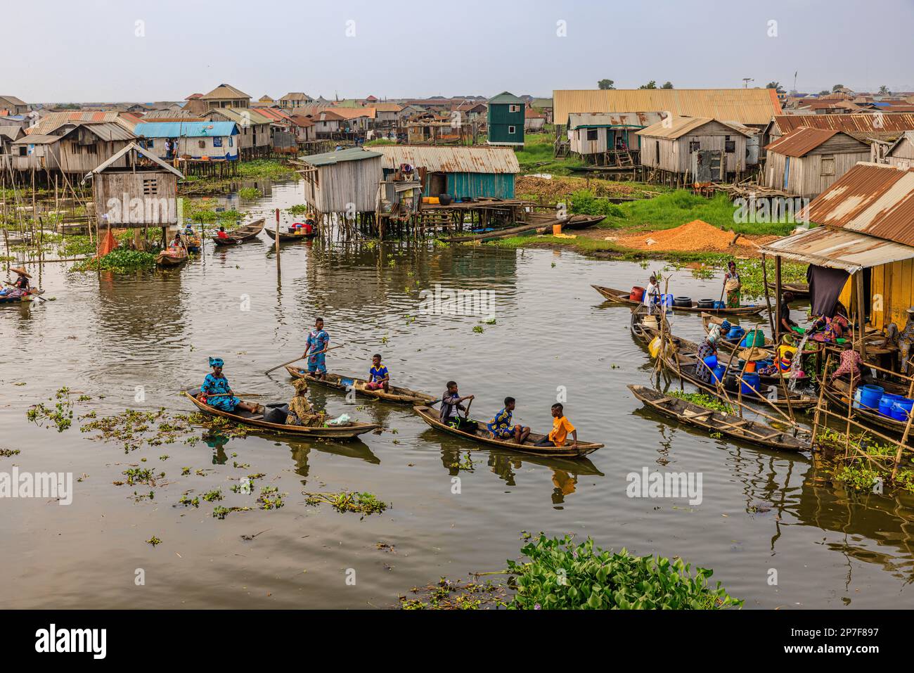 Aus der Vogelperspektive sehen Sie traditionelle hölzerne Boote, die zum schwimmenden Markt am See Nokwie benin paddeln Stockfoto